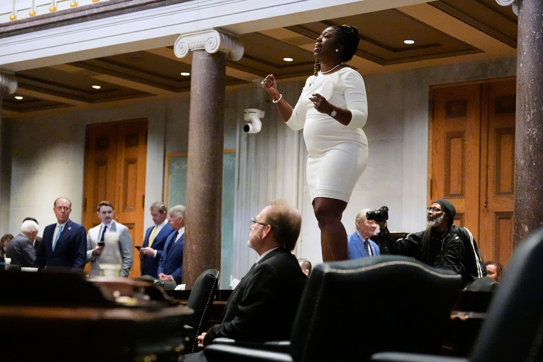 Sen. Charlane Oliver sings atop her desk in the Senate chamber as she protests against the redrawing of Congressional voting maps during a special session of the state legislature.