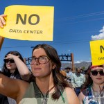 A row of women protesters hold up signs saying No Data Center.