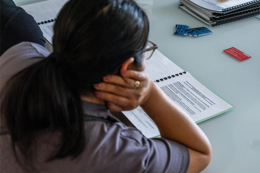 A person seen from behind reads a document at a table