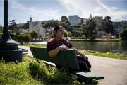 Woman sitting on a bench at Lake Merritt in Oakland, California