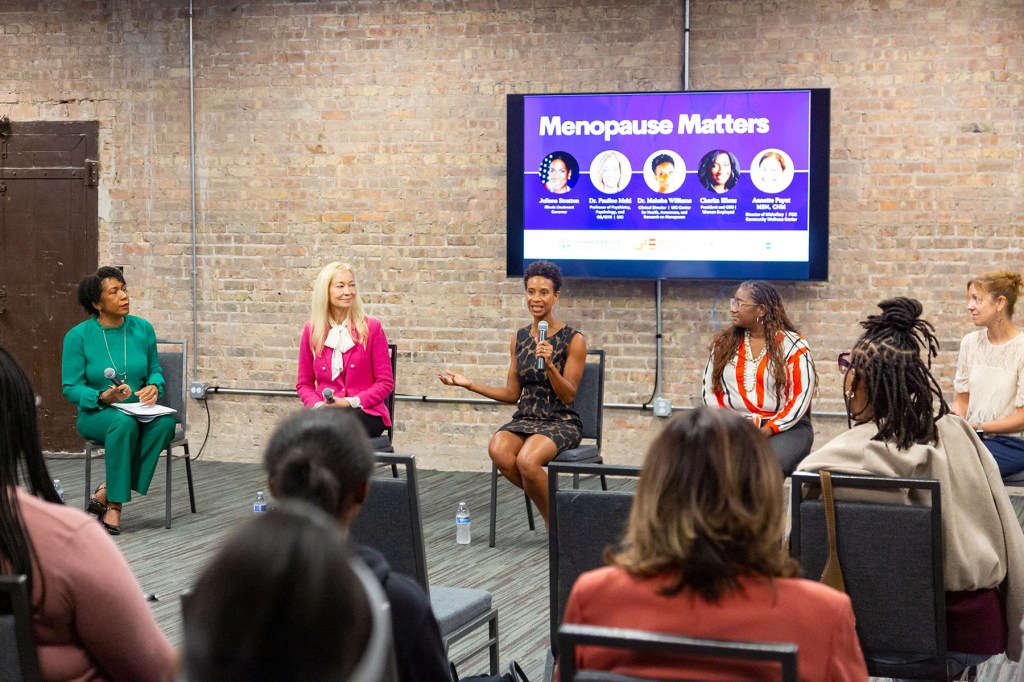 Panelists speak during a Menopause Matters event in Chicago as audience members sit facing the stage.