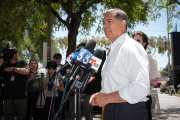 Xavier Becerra speaks into multiple microphones