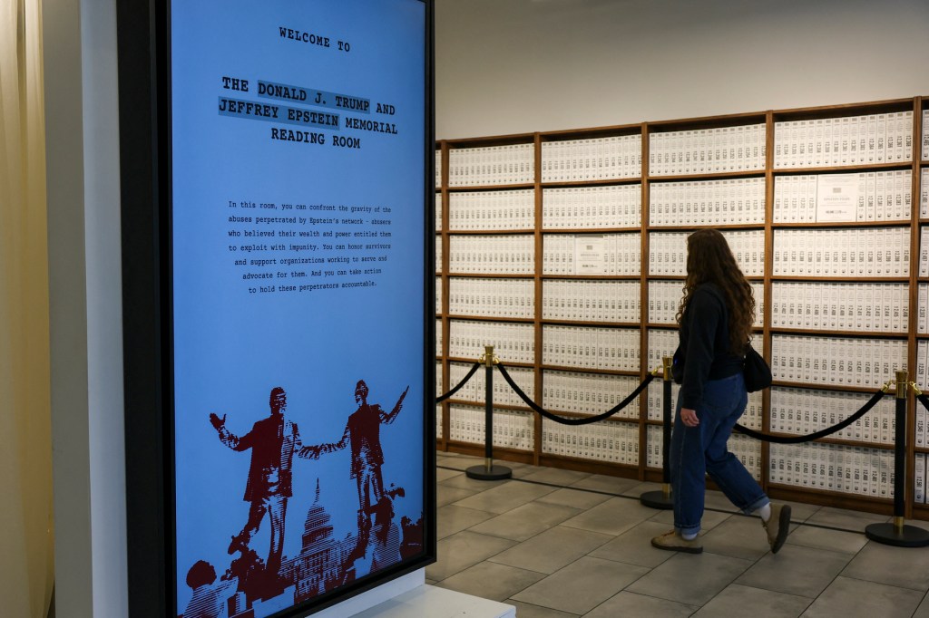 Visitors look at a timeline of events at the “Donald J. Trump and Jeffrey Epstein Memorial Reading Room”, a tribute to the survivors and victims of Epstein's crimes, where 3.5 million pages, 3,437 bound volumes of the Epstein files are displayed in New York City.