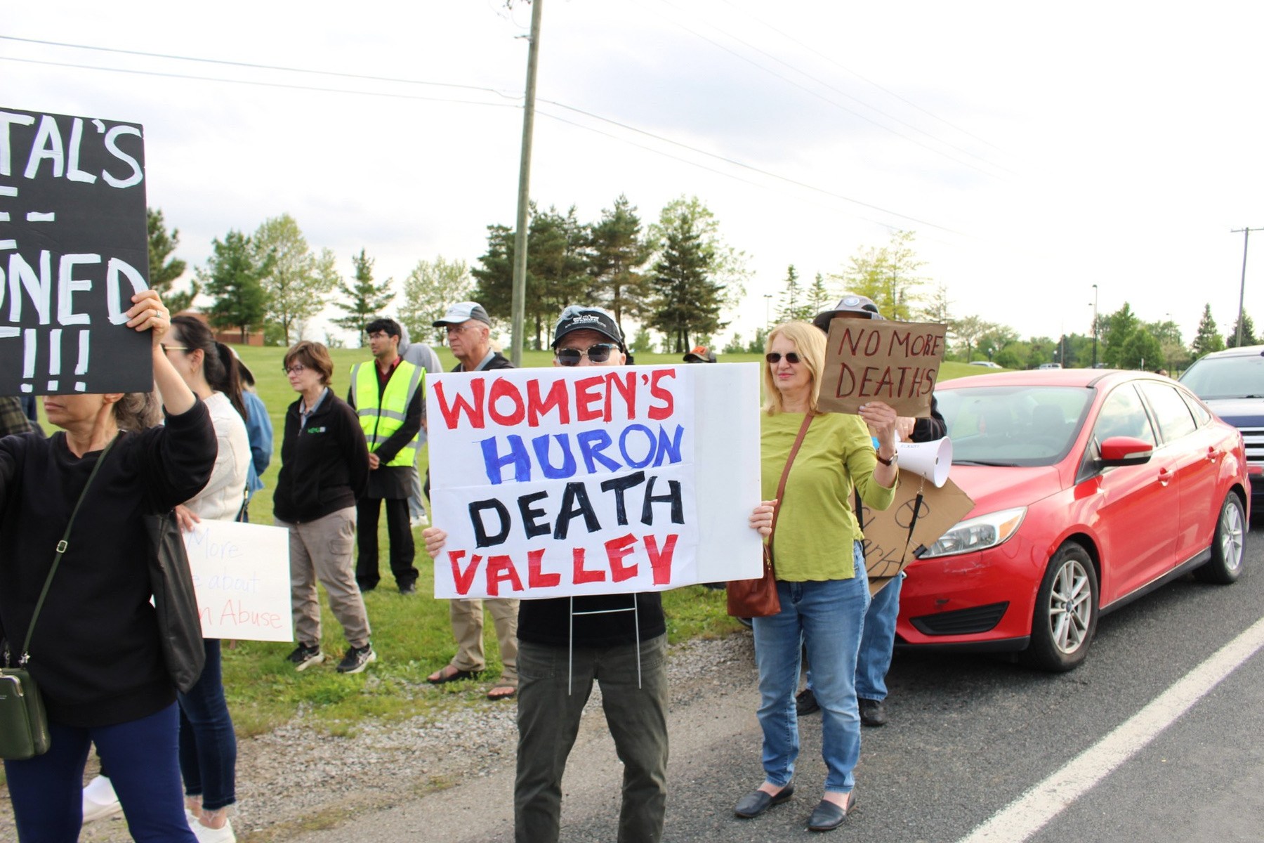 People hold signs at a protest outside of the Women's Huron Valley Correctional Facility in Washtenaw County, Michigan.