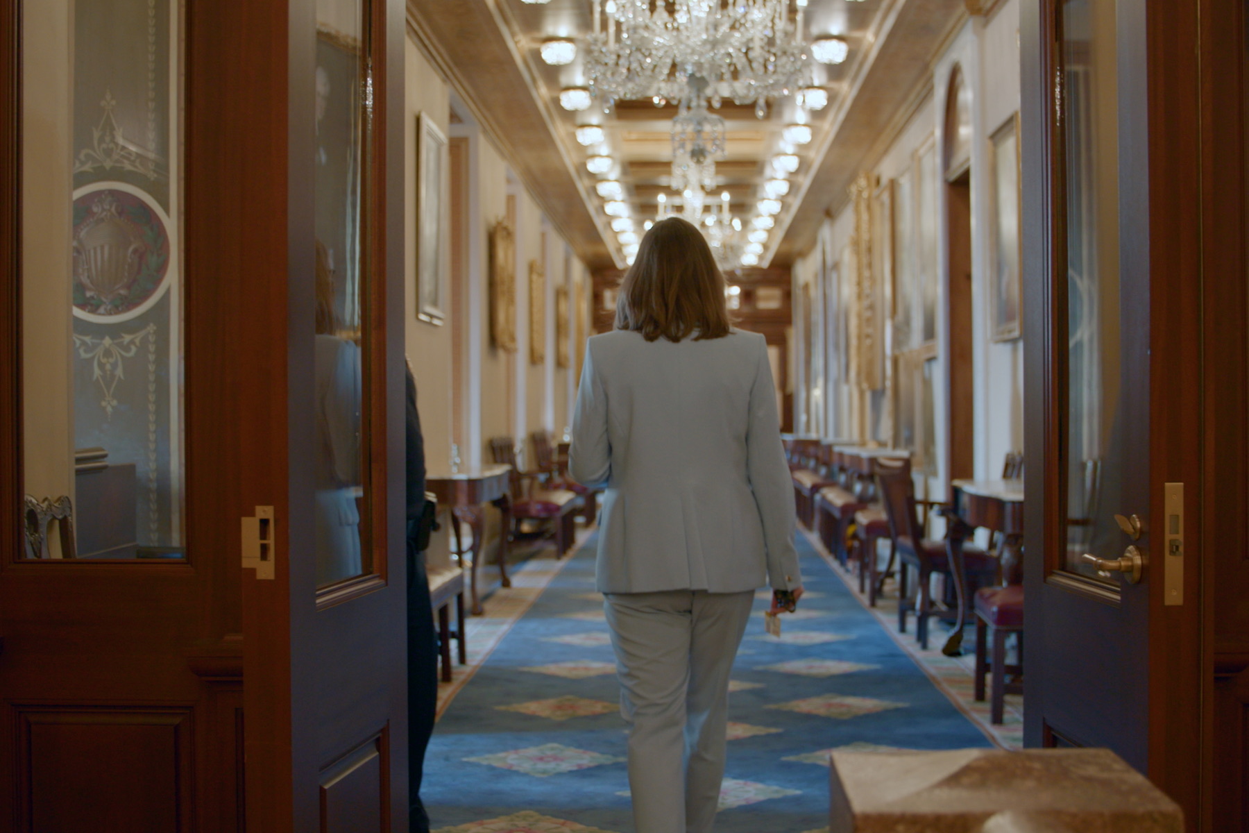 Sarah McBride walks away down a long hallway.
