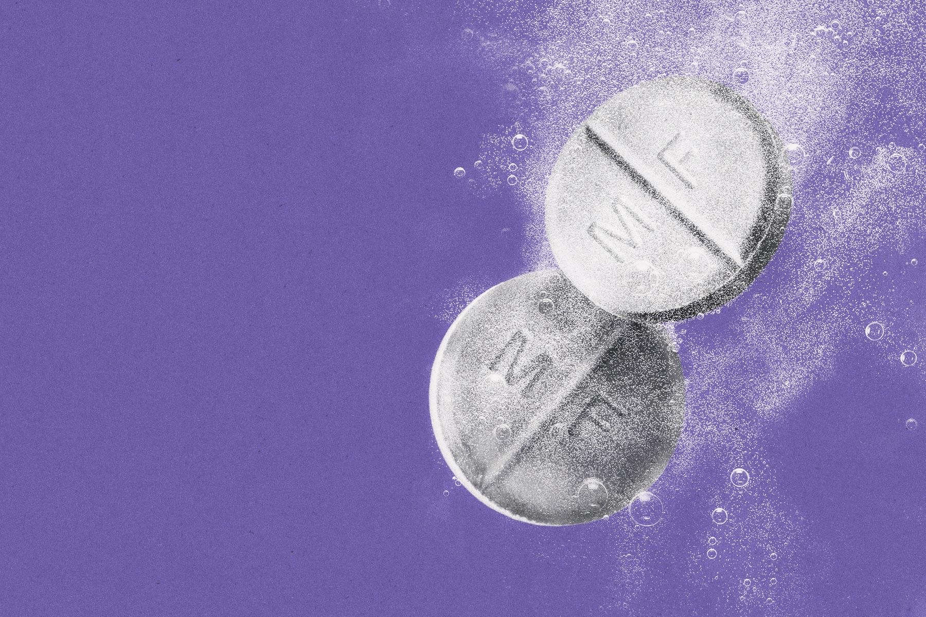 Two mifepristone pills appear submerged in water on a purple background.