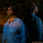 Mo Turner stands for a portrait image against a dark background.
