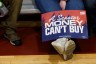 A supporter displays a red and blue sign that reads 'A Senator Money Can't Buy', at the Primary Election event for Democratic U.S. Senate candidate Graham Platner on June 9, 2026 in Blue Hill, Maine.