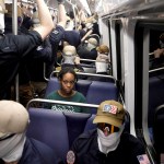 A commuter looks on as masked members of the White nationalist group Patriot Front ride the metro on the 250th anniversary of independence.