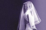 A young girl wearing a veil and a white dress stands against a dark purple background.