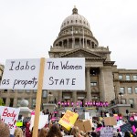 Protesters holding signs rally for abortion rights outside of the Idaho Statehouse.