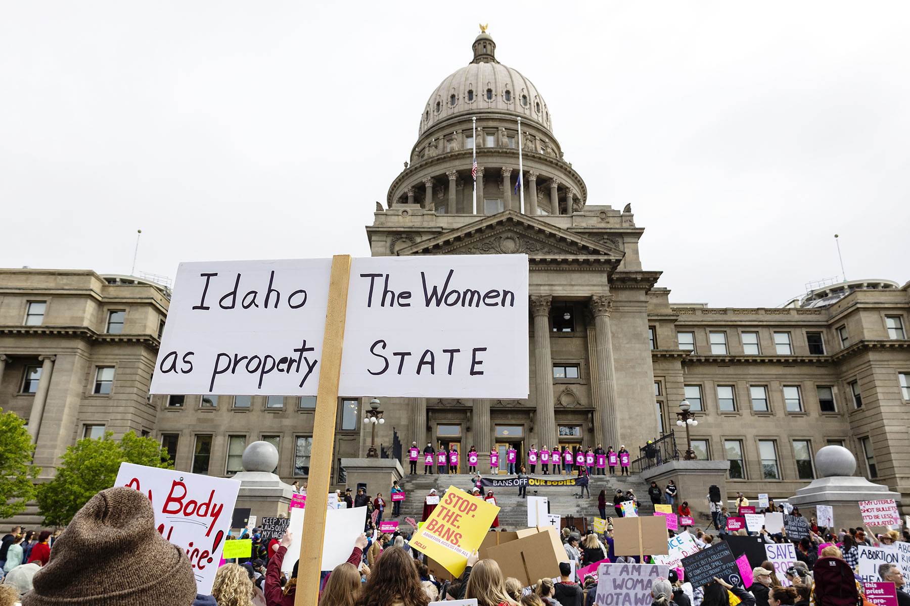 Protesters holding signs rally for abortion rights outside of the Idaho Statehouse.