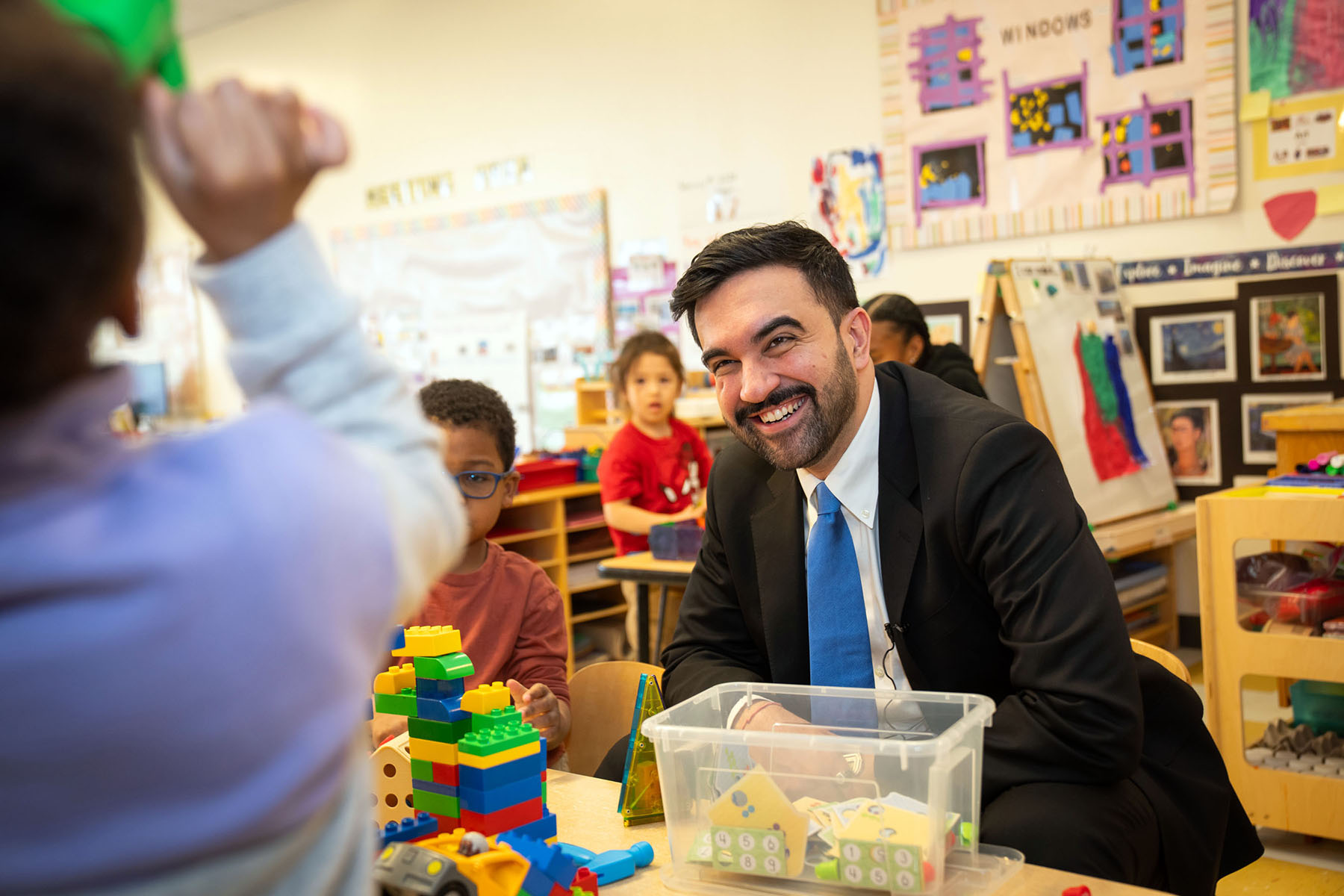 New York City Mayor Zohran Mamdani smiles and plays with children as he visits a child care center in the Bronx.