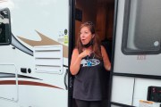 A woman stands in the doorway of an RV.