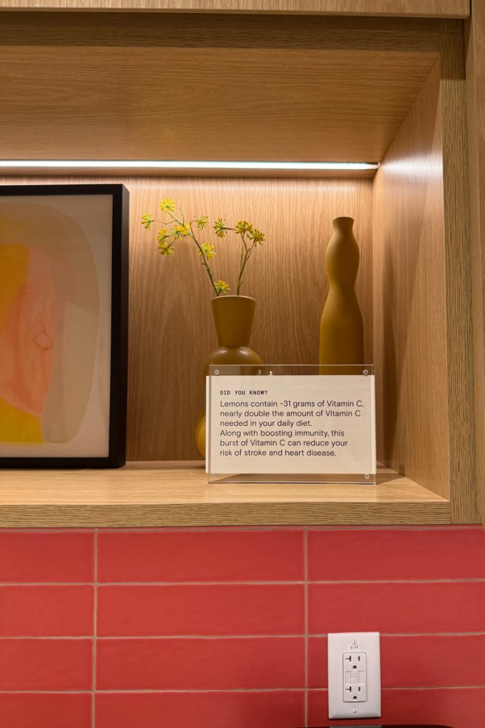 Earth tone decorations sit on a shelf alongside a note with health info.