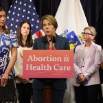 Massachusetts Gov. Maura Healy stands at a podium with 