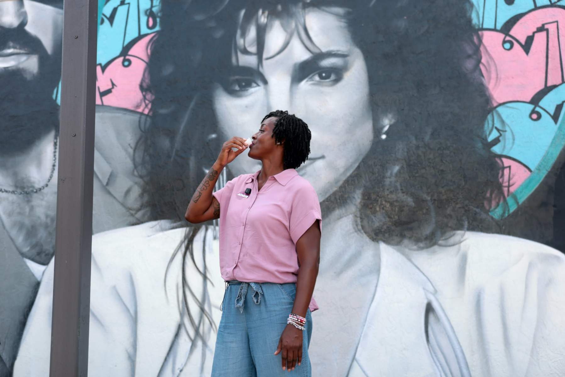 Florida state Rep. Angie Nixon drinks a Cuban coffee in front of a mural of singer Gloria Estefan on a tour of the Little Havana neighborhood in Miami.
