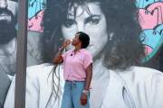 Florida state Rep. Angie Nixon drinks a Cuban coffee in front of a mural of singer Gloria Estefan on a tour of the Little Havana neighborhood in Miami.