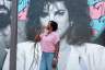 Florida state Rep. Angie Nixon drinks a Cuban coffee in front of a mural of singer Gloria Estefan on a tour of the Little Havana neighborhood in Miami.