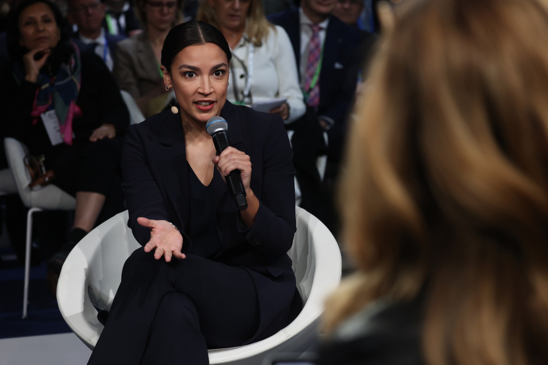 Alexandria Ocasio-Cortez, U.S. representative for New York's 14th congressional district, speaks into a microphone at an event.