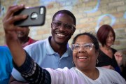 Democratic Wisconsin gubernatorial candidate David Crowley smiles as he takes a selfie with a supporter at a campaign rally.