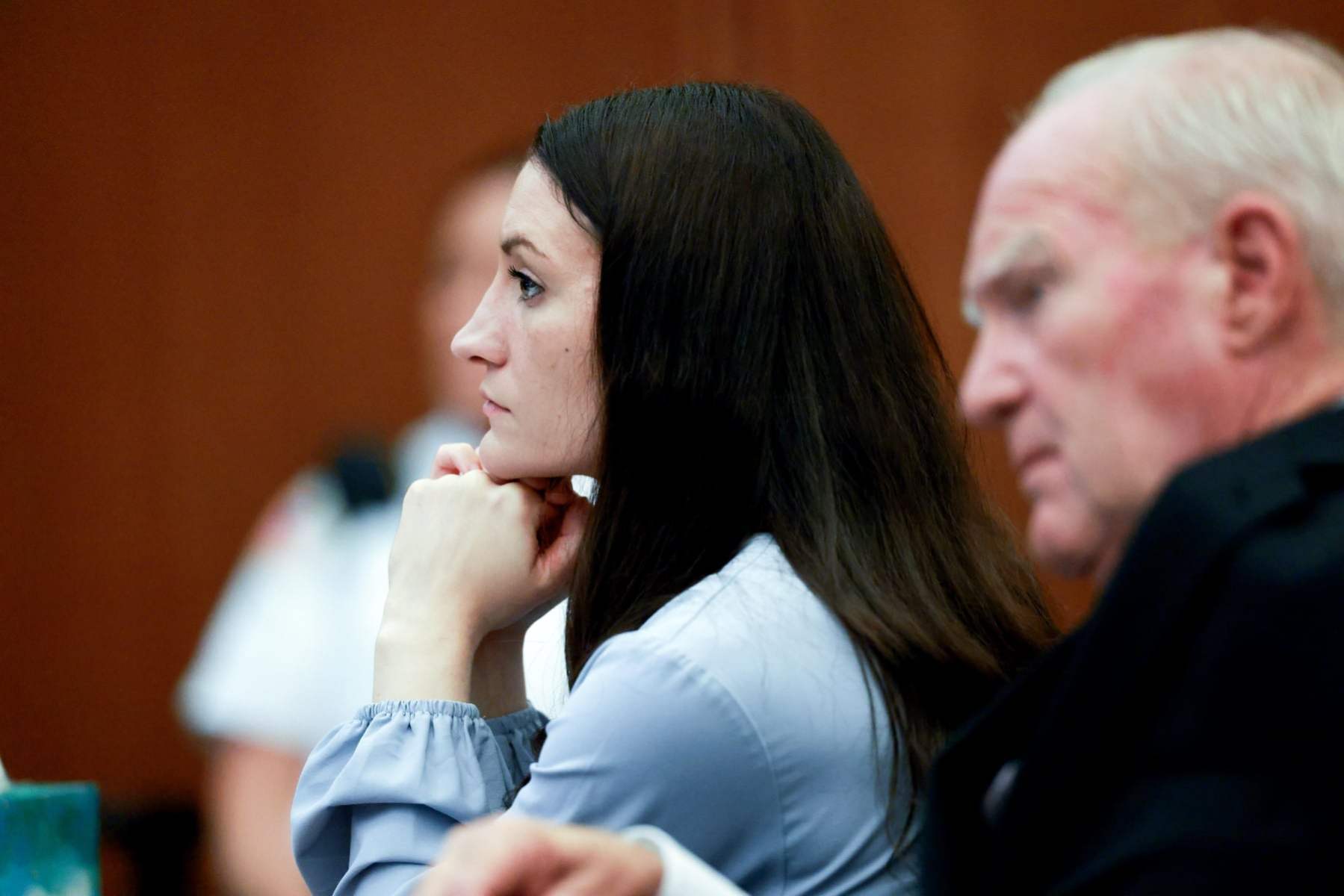 Lindsay Clancy is seen in profile, sitting at her trial next to her defense attorney