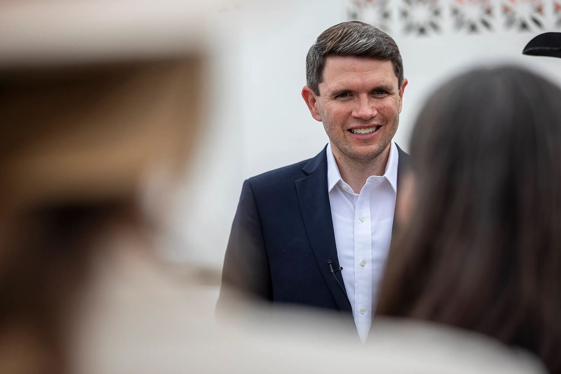 James Talarico smiles as he talks to local officials after a campaign stop.