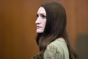 Clancy looks pensively off frame in the courtroom.