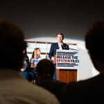 James Talarico speaks at a podium with a sign reading 