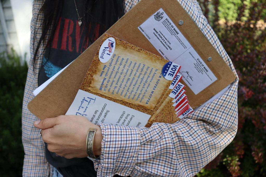 A closeup on a hand holding campaign materials.