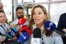 Rep. Maria Elvira Salazar speaks to reporters as a crowd of microphones surrounds her during a press scrum.