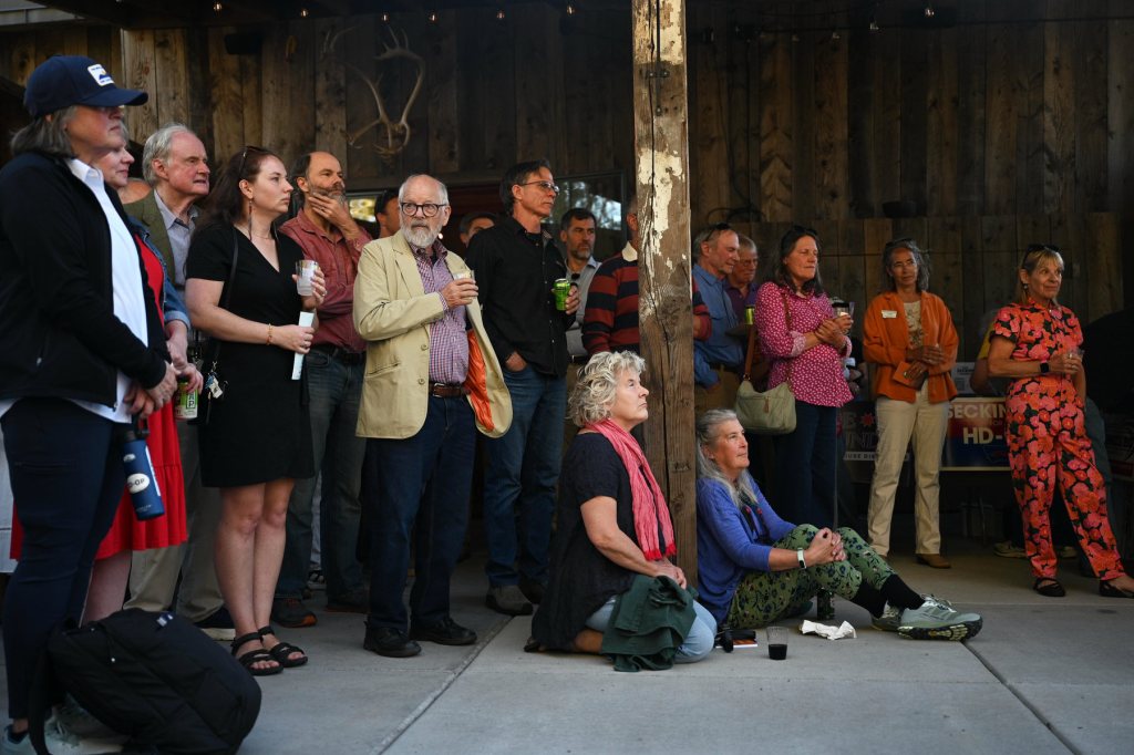 A group of people attend the Fire Thunder campaign event, listening as she speaks off camera.