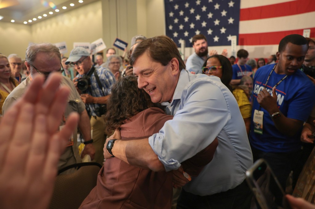 Jackson hugs a person during a campaign event.
