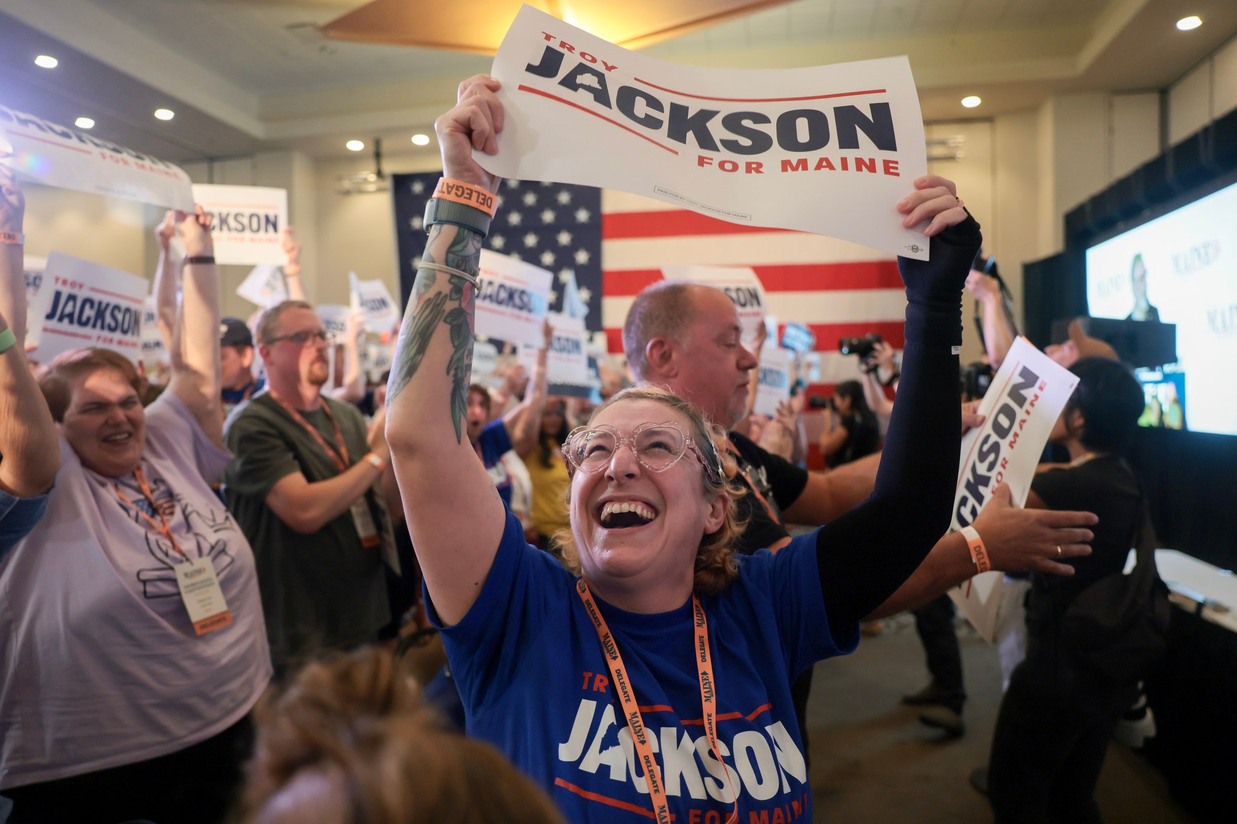 A laughing woman hoists a sign for Jackson during a campaign event.
