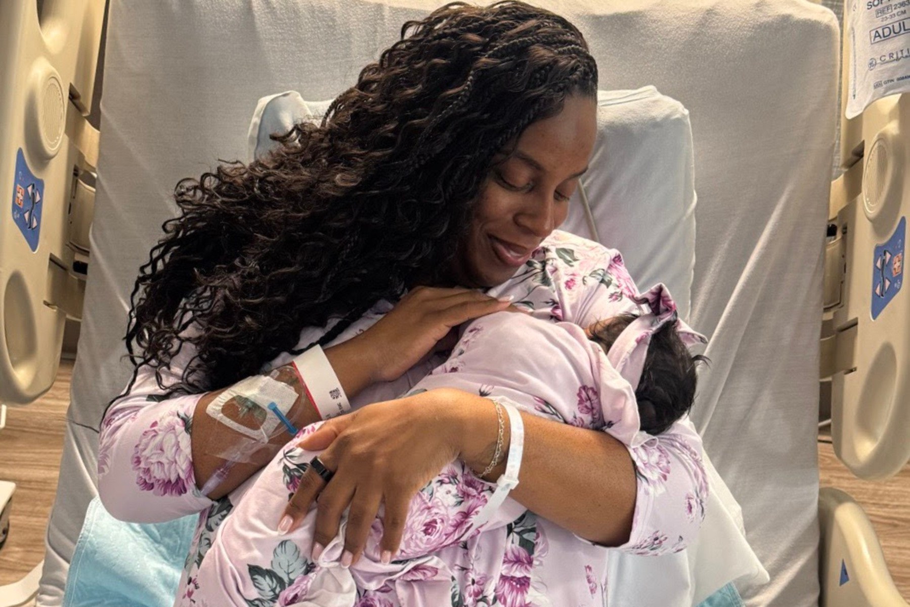 Rep. LaMonica McIver holds her newborn daughter in a hospital bed.