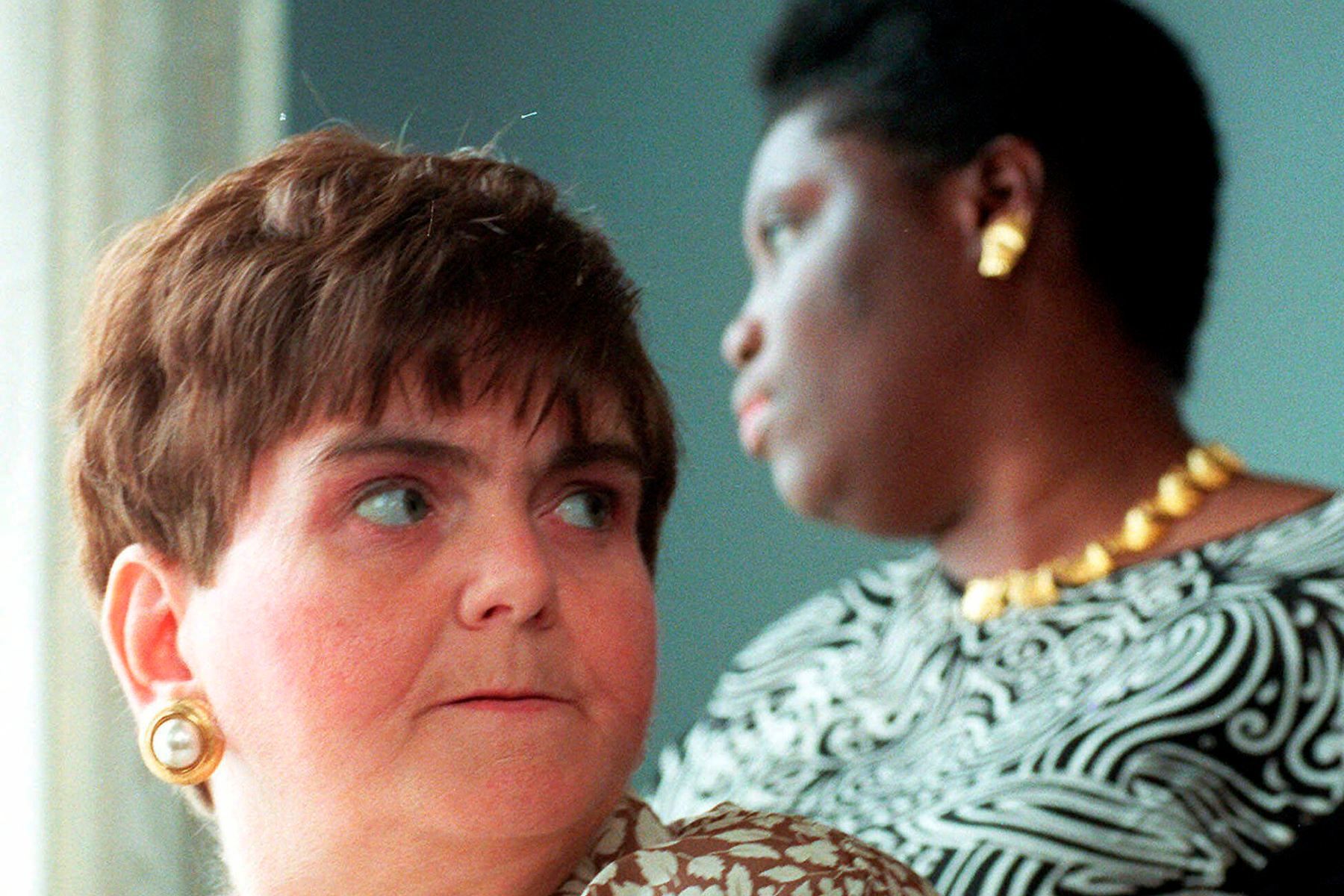 Two women look in opposite directions in closeup.